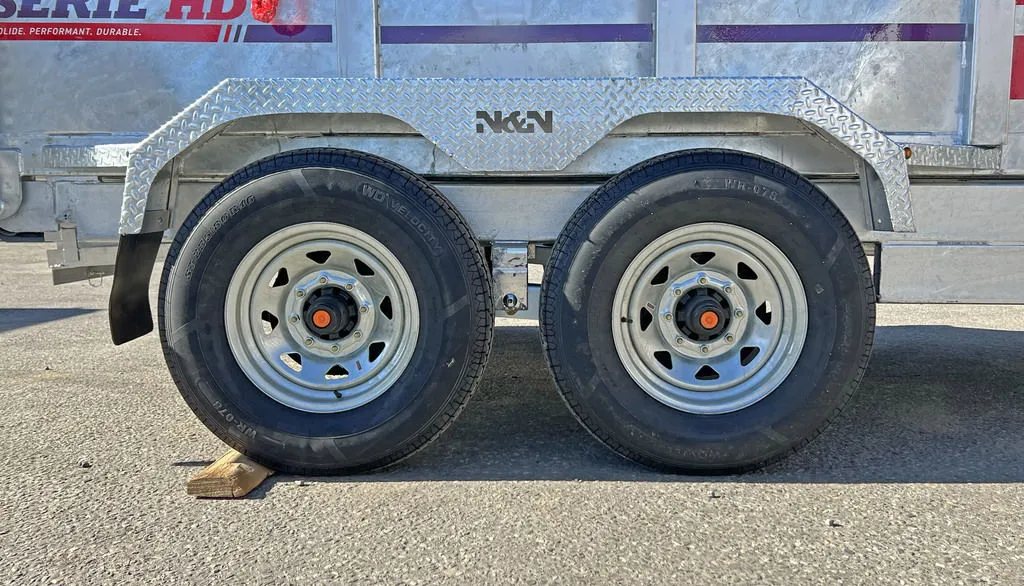 2024 N&N Trailers 14 ft Dump – Galvanized Steel – Close-up of the tandem wheels and galvanized fender with a manufacturer cutout