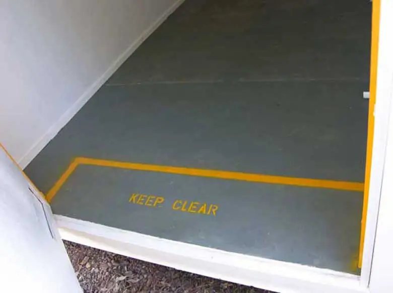 Explosive Storage Magazine – White, Insulated – Interior grey floor at entrance with yellow safety line and keep clear text