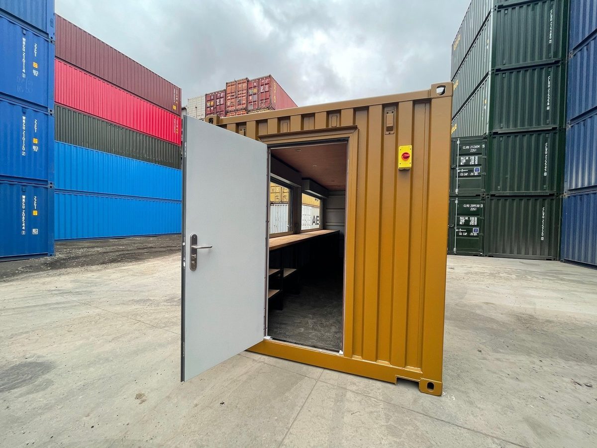20ft High Cube Container Bar – Multiple Serving Hatches – Open entrance door revealing container bar counter and shelving