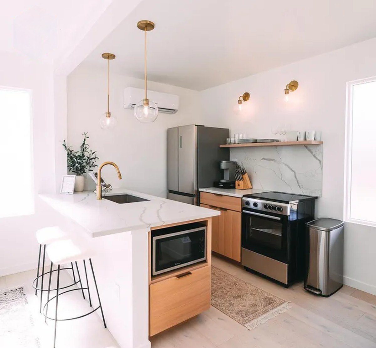 3-Bedroom Duplex Container Home – Rooftop Deck – Quartz waterfall island and white oak cabinetry, with stainless appliances shown — furniture and appliances shown for illustration only; not included