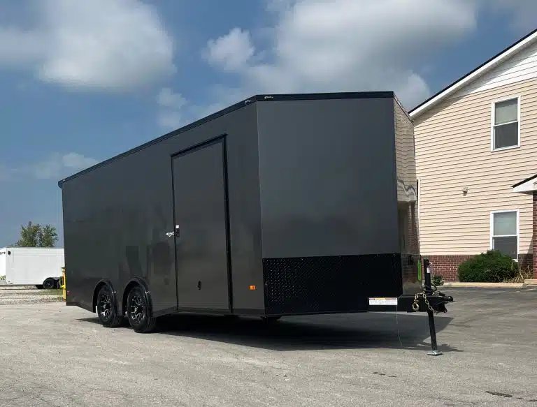 2025 Millennium 20 ft Car Hauler – Black-Out Package – Front side view showing the passenger door and v-nose of the charcoal gray trailer