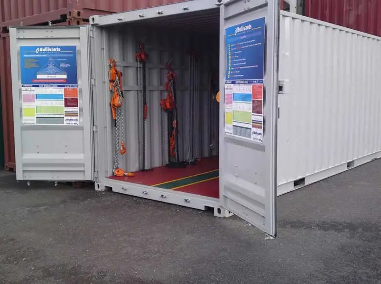 Trade Show Display Container – Lockable Steel Booth – Open end doors of a white shipping container showing internal storage racks