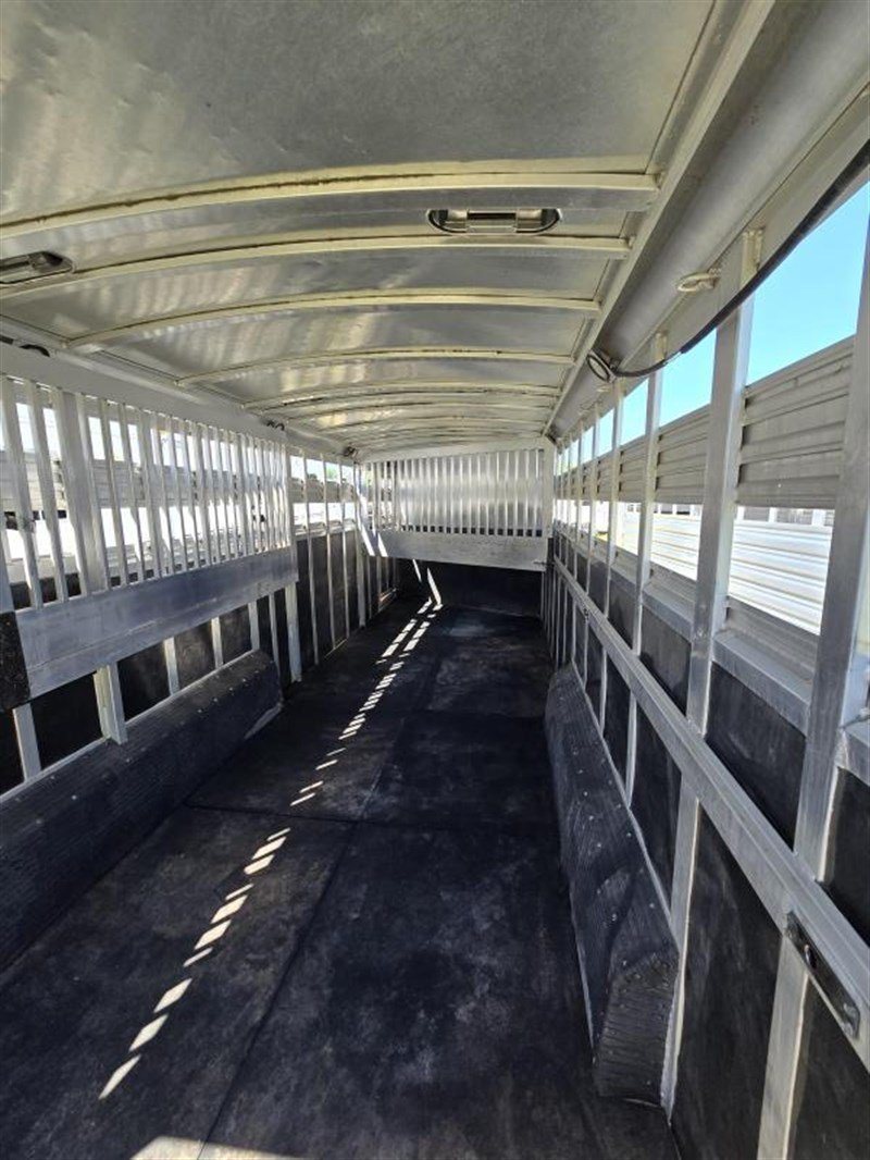 2006 C&C 4 Horse Gooseneck Trailer – Dual Hay Racks – Empty interior of the horse trailer looking toward the front with metal slats