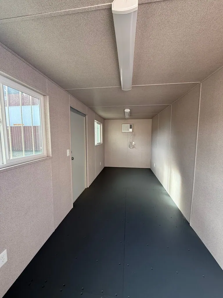 20ft Ground-Level Office Container – Insulated Workspace – empty office interior with windows and wall-mounted air conditioner
