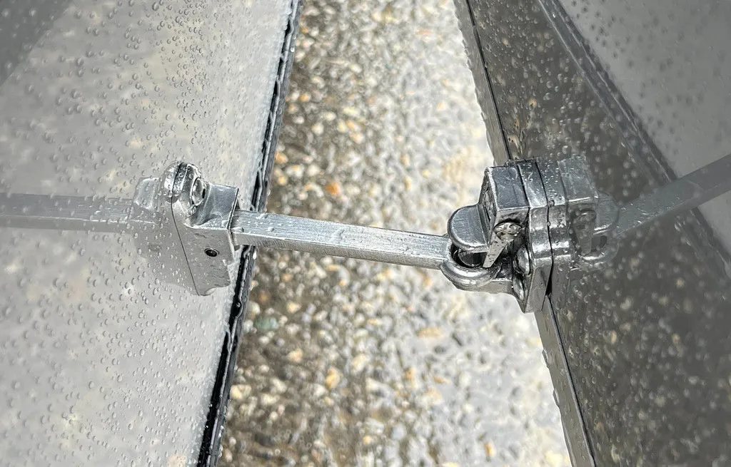 2024 Mission Trailers Crossover Trailer – Galvanized Package – Close-up of a metal door holder hardware connecting door to side