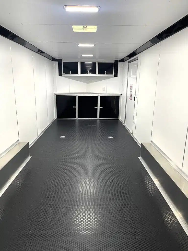 2026 Millennium 26 ft Car Hauler – White Aluminum – Interior view showing the front cabinets and finished white walls and ceiling