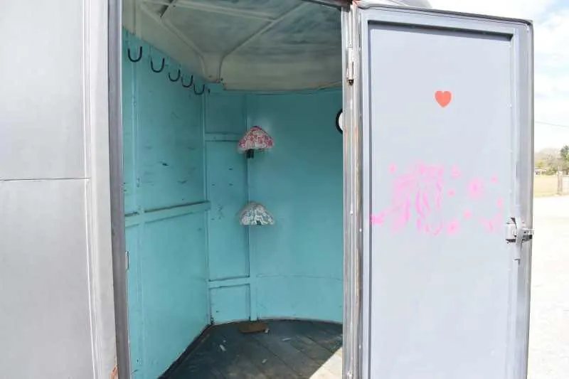 2007 WW 2HSL 2 Horse Trailer – Front Dressing Room – Front tack room interior with light blue walls and saddle racks