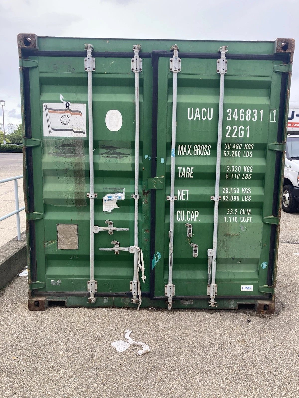 20ft Used Shipping Container – Ground-Level Storage – front view of weathered green container with closed cargo doors