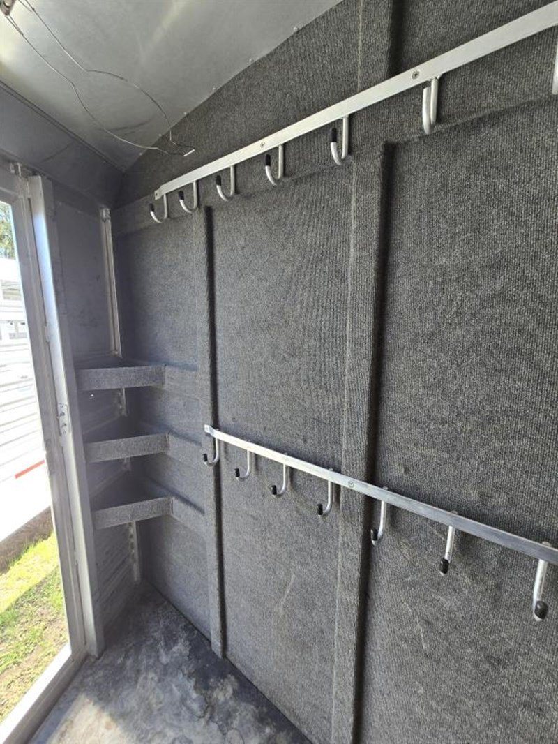 2006 C&C 4 Horse Gooseneck Trailer – Dual Hay Racks – Close-up of the carpeted wall in the tack room with double rows of hooks