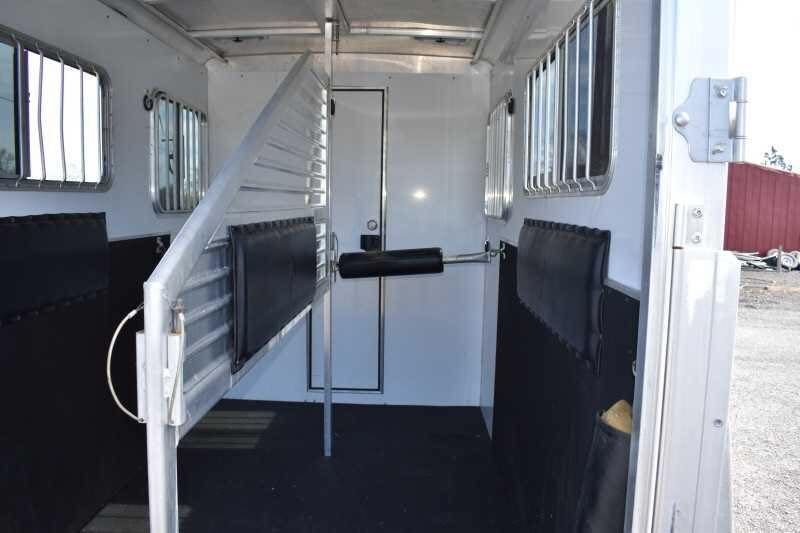 2005 Featherlite 2HST Horse Trailer – Walk-Through Dressing Room – Interior horse stall area with padded dividers and rubber mats