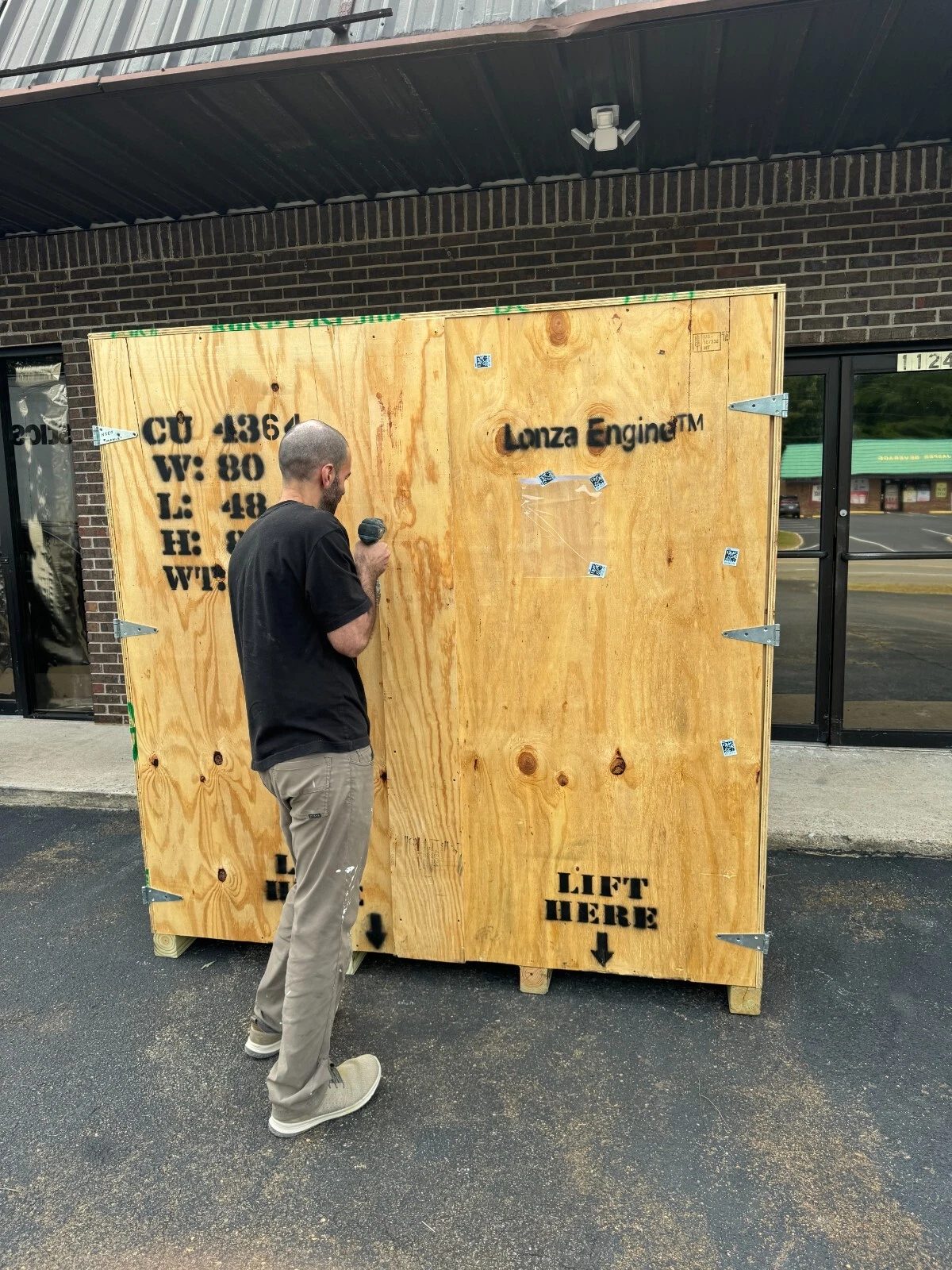 80in Used Wooden Shipping Crate – Reinforced Corners – large wooden shipping crate partially obscured by a person