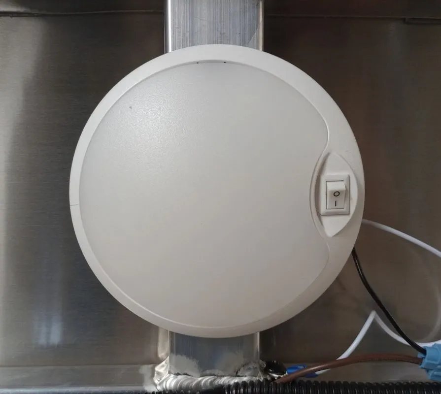 Mission Trailers Aluminum Crossover – Rear Canopy – Close-up of a round white interior dome light with a power switch