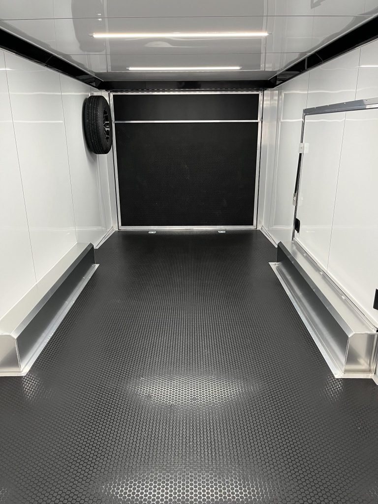 2026 ATC 24 ft Car Hauler – Black, Plus Package – Clean white interior of the trailer showing the black floor and spare tire mounted