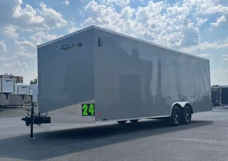 2026 Millennium Hero 24 ft Car Hauler – Gray Dove – A three-quarter exterior view of a silver enclosed trailer with two axles and hitch