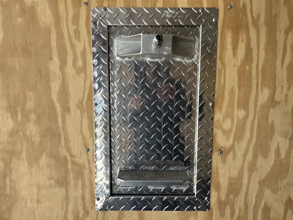 2008 Sno Pro 4-Place Snowmobile Trailer – Black Aluminum – Rectangular metal bracket mounted on a wood interior wall