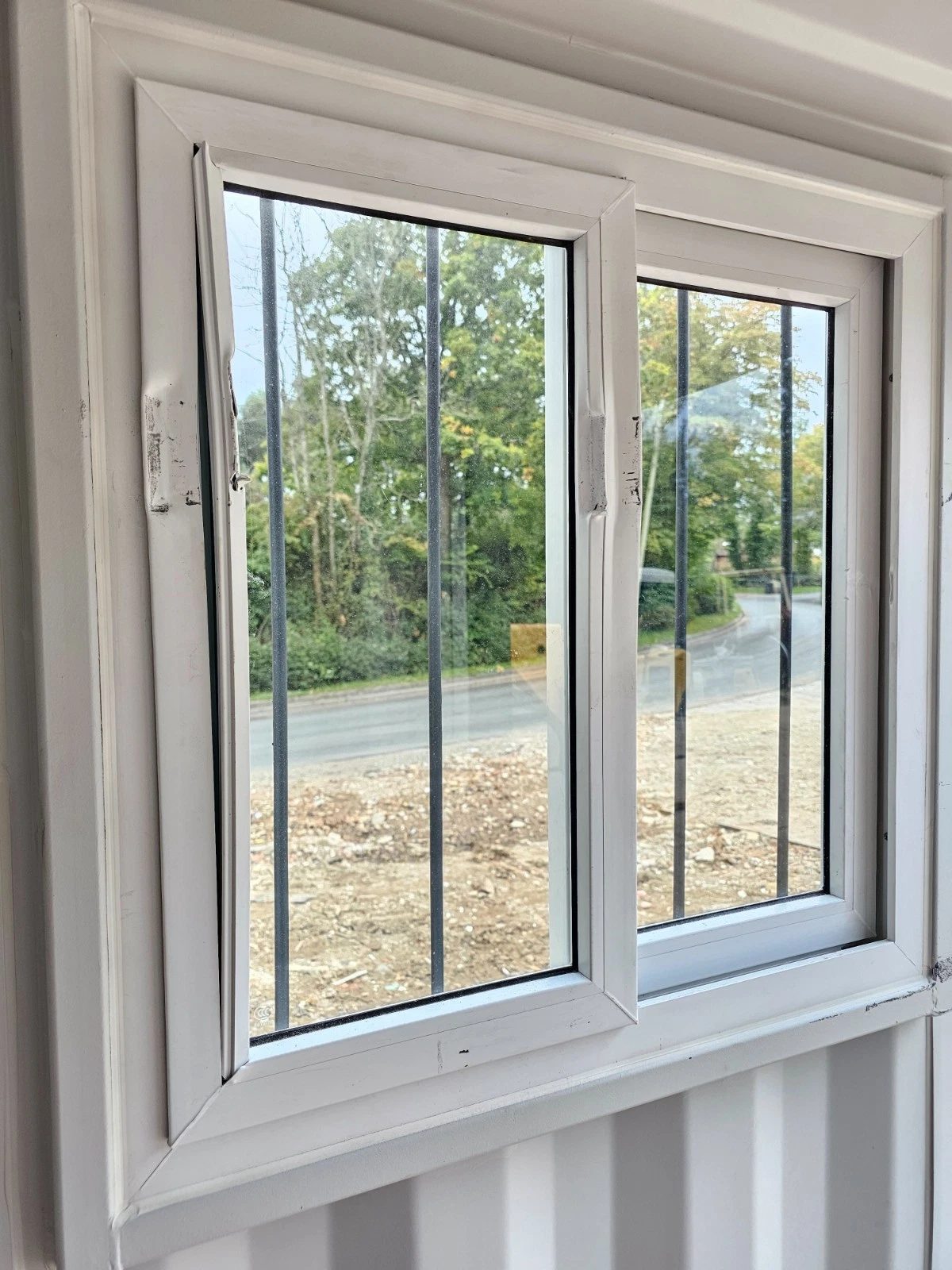 8ft New Shipping Container – Lockbox and Barred Windows – interior close-up of white framed window with security bars