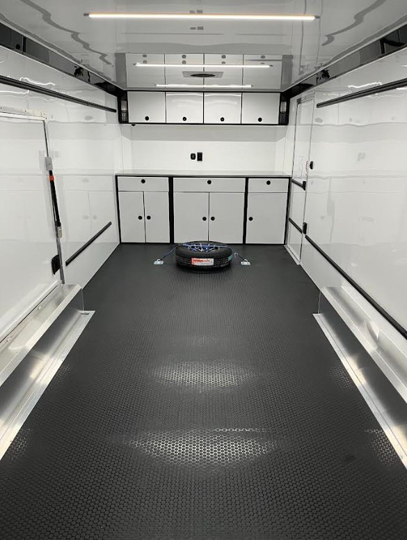 2026 ATC 24 ft ROM 550 – Lithium Power – Clean white interior with black textured flooring, white cabinets and a spare tire