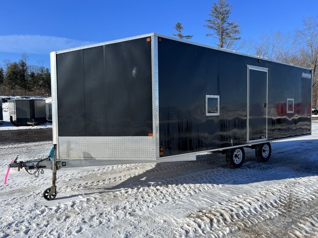 2008 Sno Pro 4-Place Snowmobile Trailer – Black Aluminum – Front three-quarter view of the black enclosed trailer parked on snow