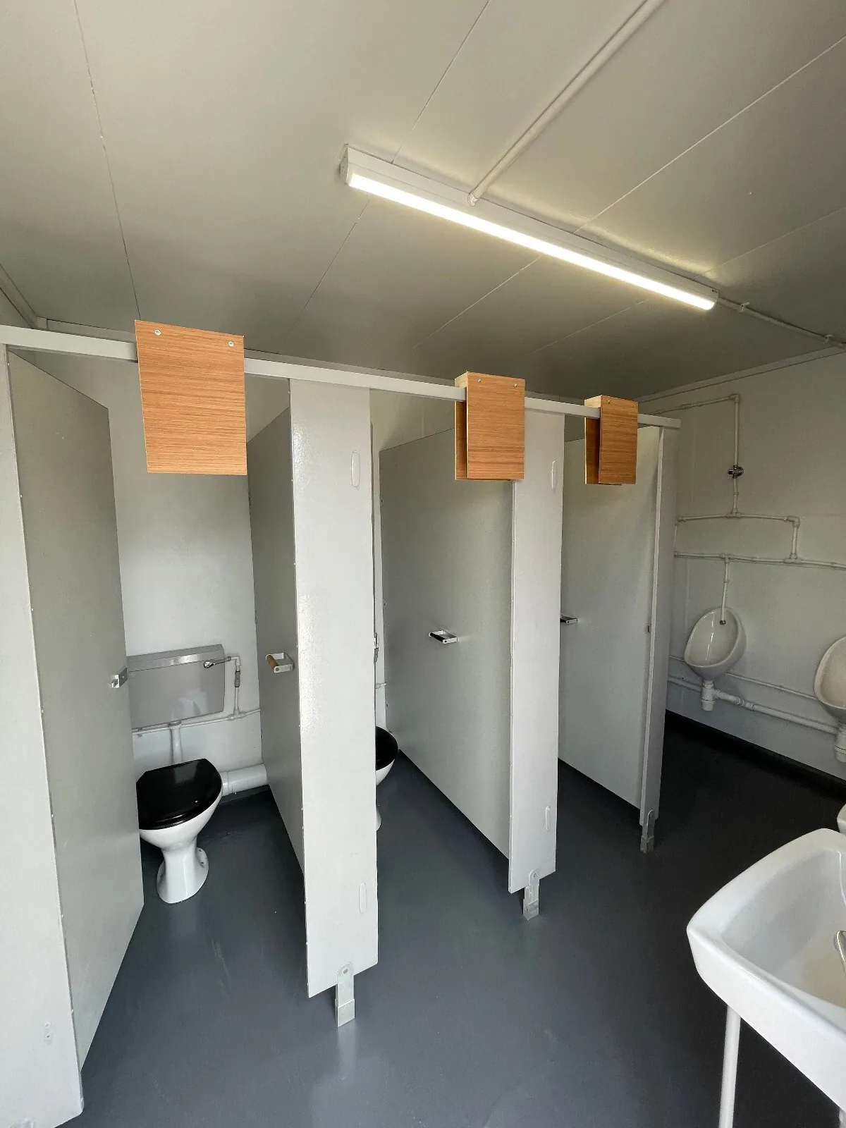 16ft × 9ft Modular Toilet Block – 3+1 Compartment Layout – Sanitation unit interior with toilet cubicles, urinals and washbasin