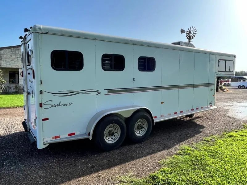 2004 Sundowner 3 Horse Trailer – Weekender Living Quarters – Rear three-quarter view of the trailer showing windows and the tandem axle wheels