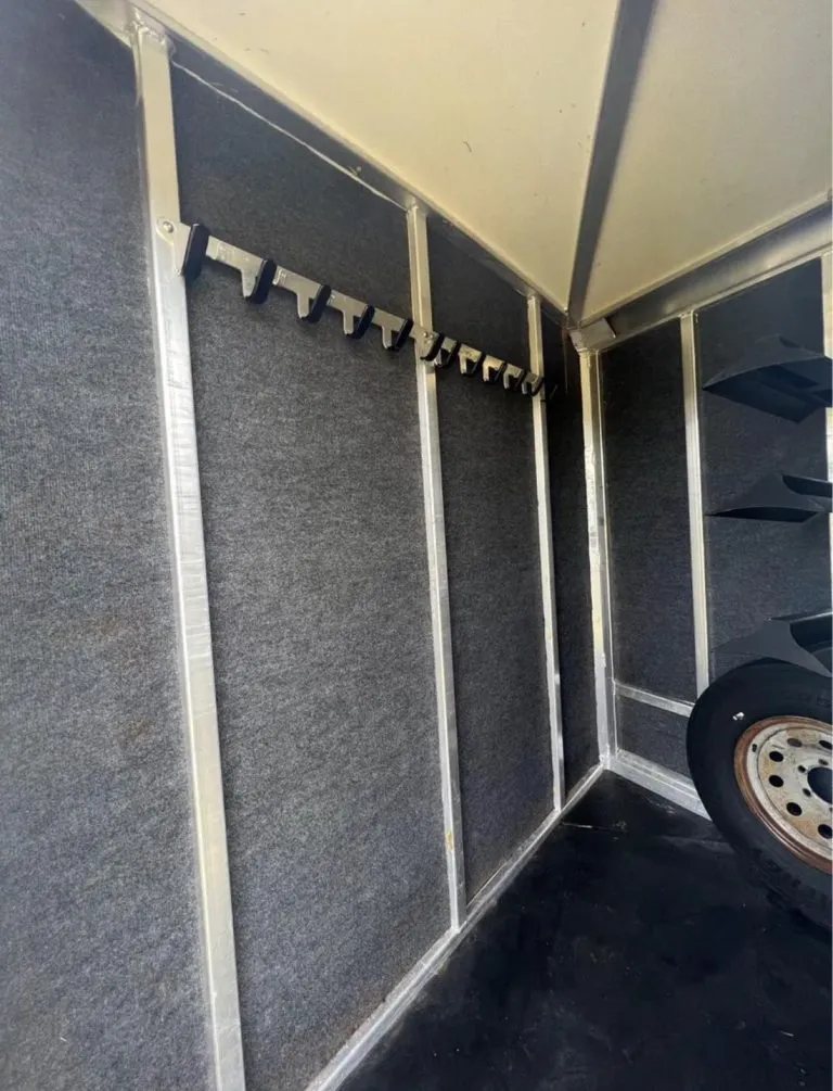 2013 Cimarron 3 Horse Bumper Pull – Aluminum, Dressing Room – Close up of black bridle hooks inside the gray carpeted tack room