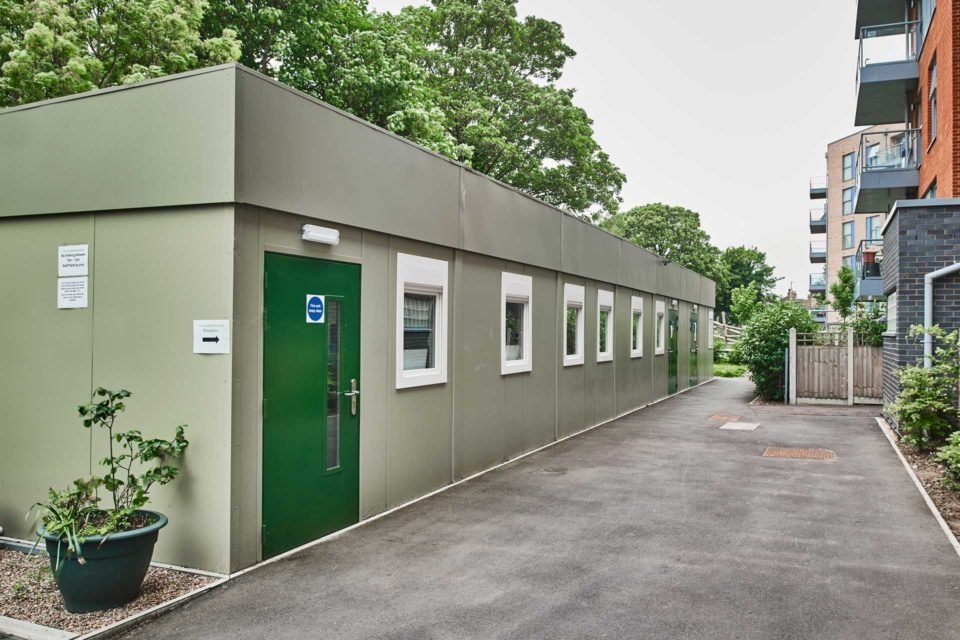32 × 30 ft Modular Office – Green, 3 Bay – Exterior view of a long olive green modular building with multiple windows and doors