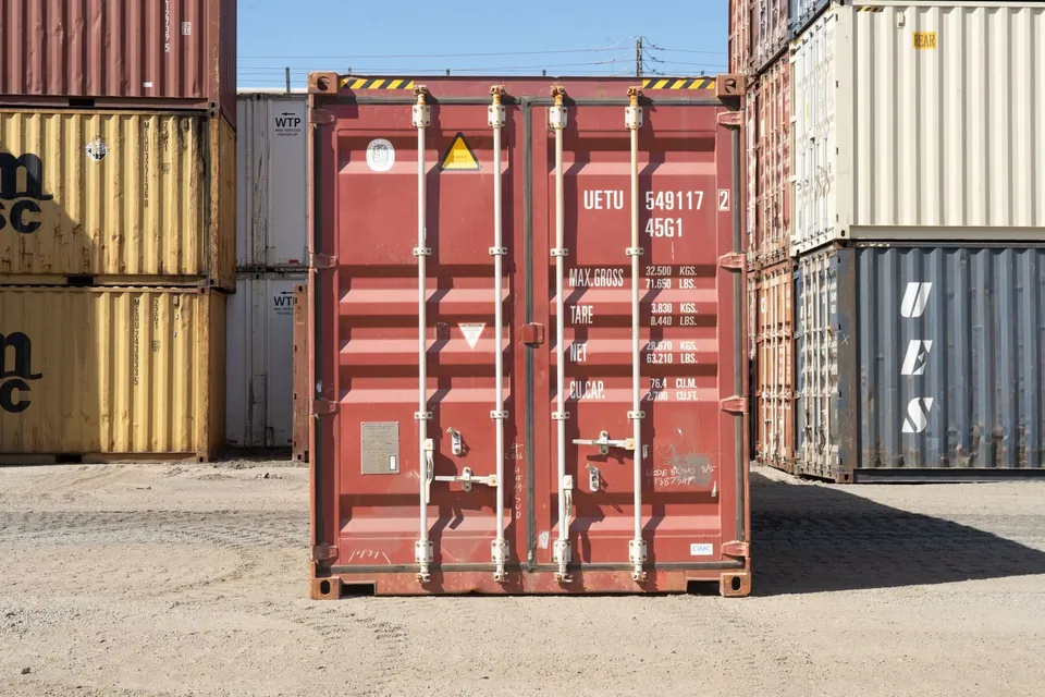 40ft High Cube Shipping Container – Used, Cargo Worthy – closed red cargo doors surrounded by stacked shipping containers