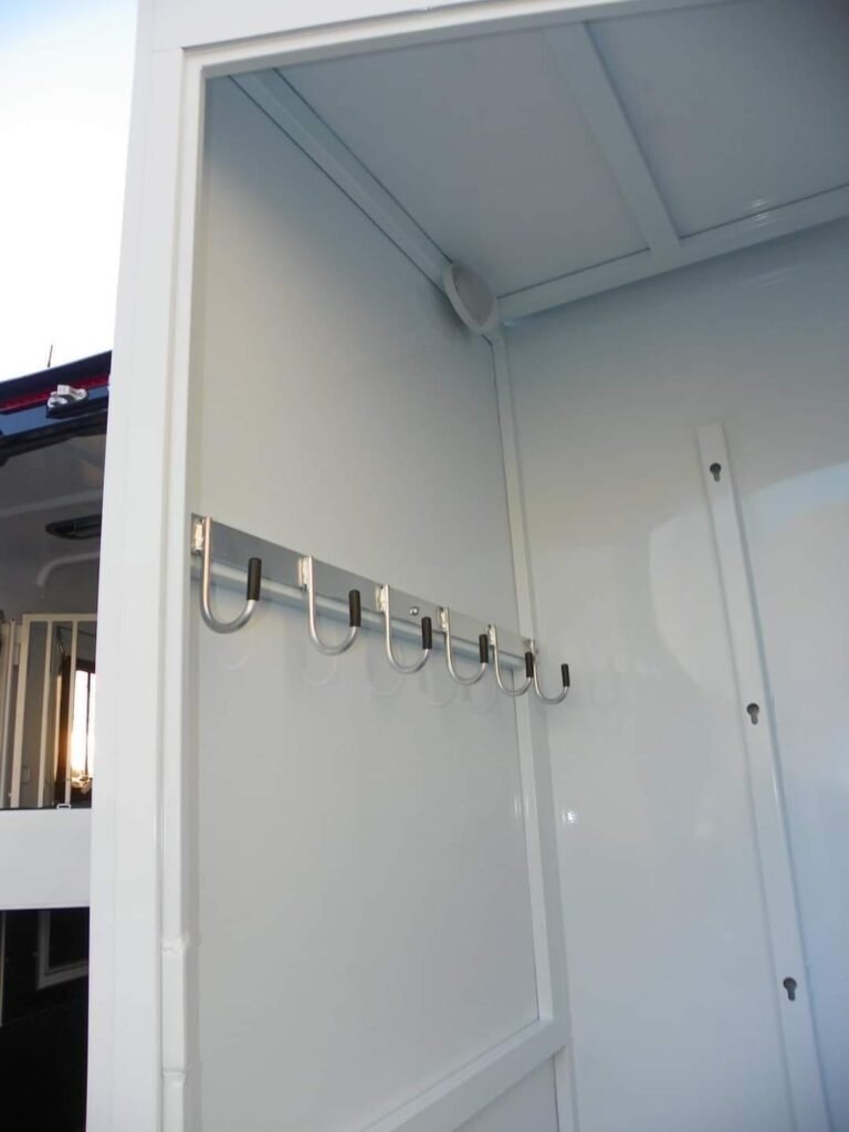 2022 Double D 2 Horse Bumper Pull – Reverse Slant – Wall mounted metal bridle hooks inside the white storage compartment