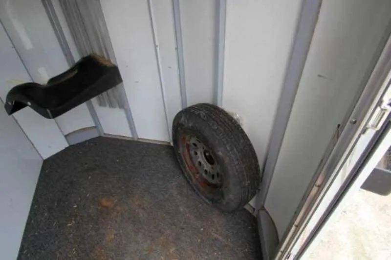 2003 Sundowner 2 Horse Trailer – Dressing Room – Floor of the tack room with a spare tire and saddle rack