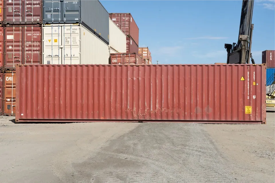 40ft High Cube Shipping Container – Used, Cargo Worthy – side view of weathered shipping container in storage yard