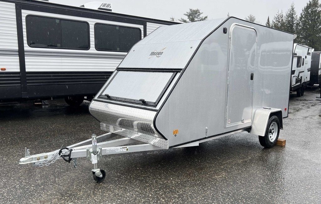2024 Mission Trailers Crossover Trailer – Galvanized Package – Front three-quarter view of a silver crossover snowmobile trailer with aerodynamic front