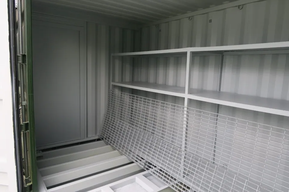 20ft Bunded Storage Container – Integrated Spill Containment – Empty container interior with shelving and lifted metal floor grating
