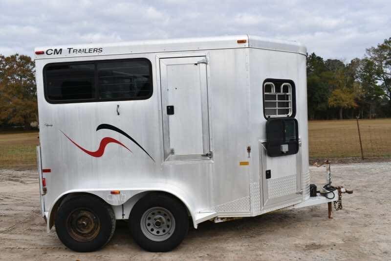 2001 CM Odyssey 2 Horse Trailer – Aluminum Floor – Full side profile of the silver trailer showing a window with protective bars