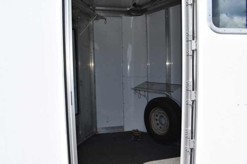 2002 Exiss SS20 2 Horse Trailer – Walk-Through Dressing Room – Interior view of the front tack room area with a spare tire