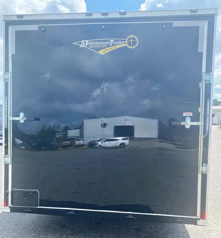 2026 Millennium 20 ft Car Trailer – Extra Height – Rear view of trailer showing closed black ramp door with dual locking bars