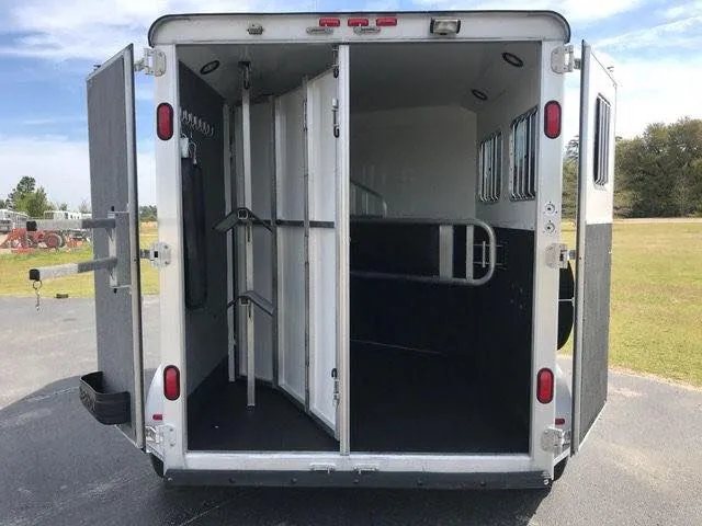 2010 Merhow 2 Horse Slant Trailer – Insulated Roof, Escape Door – Rear view with doors open showing the horse area and swing-out tack