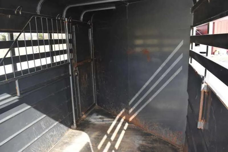 2007 WW 2HSL 2 Horse Trailer – Front Dressing Room – Interior of the horse stall area with slatted sides and a metal divider