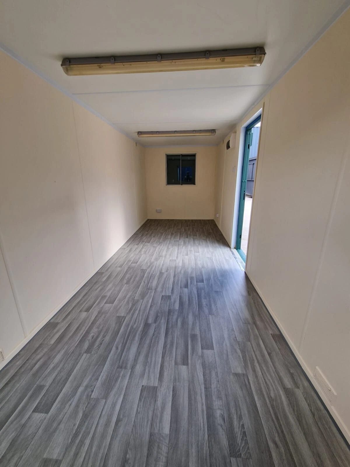 20ft Anti-Vandal Office Canteen – Insulated Steel Workspace – empty office interior with grey flooring and cream walls