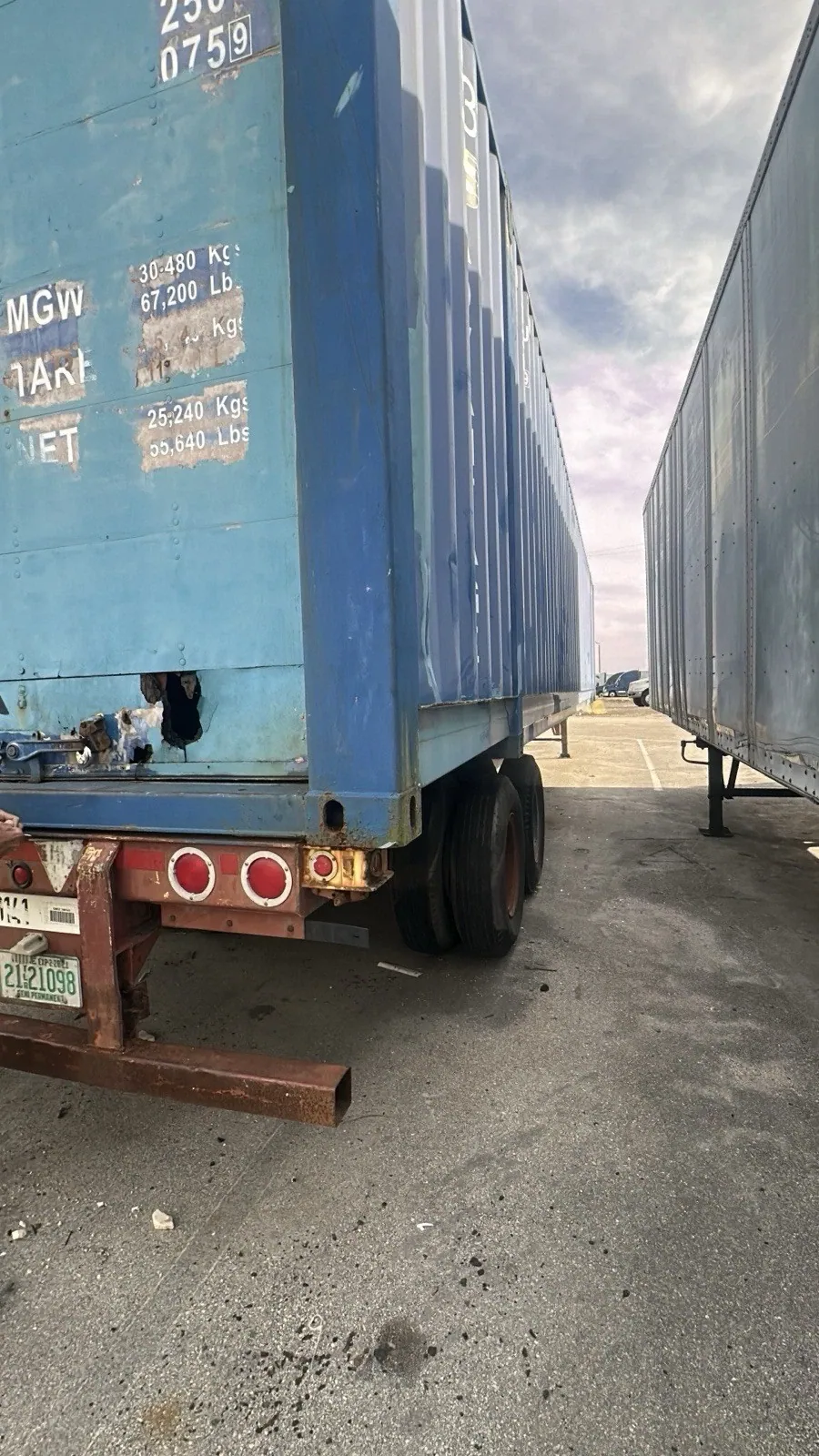 53ft High Cube Shipping Container – Used, Cargo Worthy – cropped rear and side of weathered container on chassis