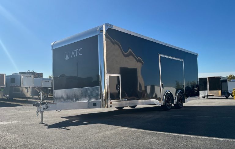 2026 ATC 24 ft ROM 550 Trailer – Black, Lithium – Front three-quarter exterior view of a black enclosed trailer showing the escape door