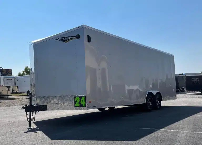 2026 Millennium 24 ft Car Hauler – Silver Hero – Front three-quarter view of a silver enclosed car hauler trailer against a clear sky
