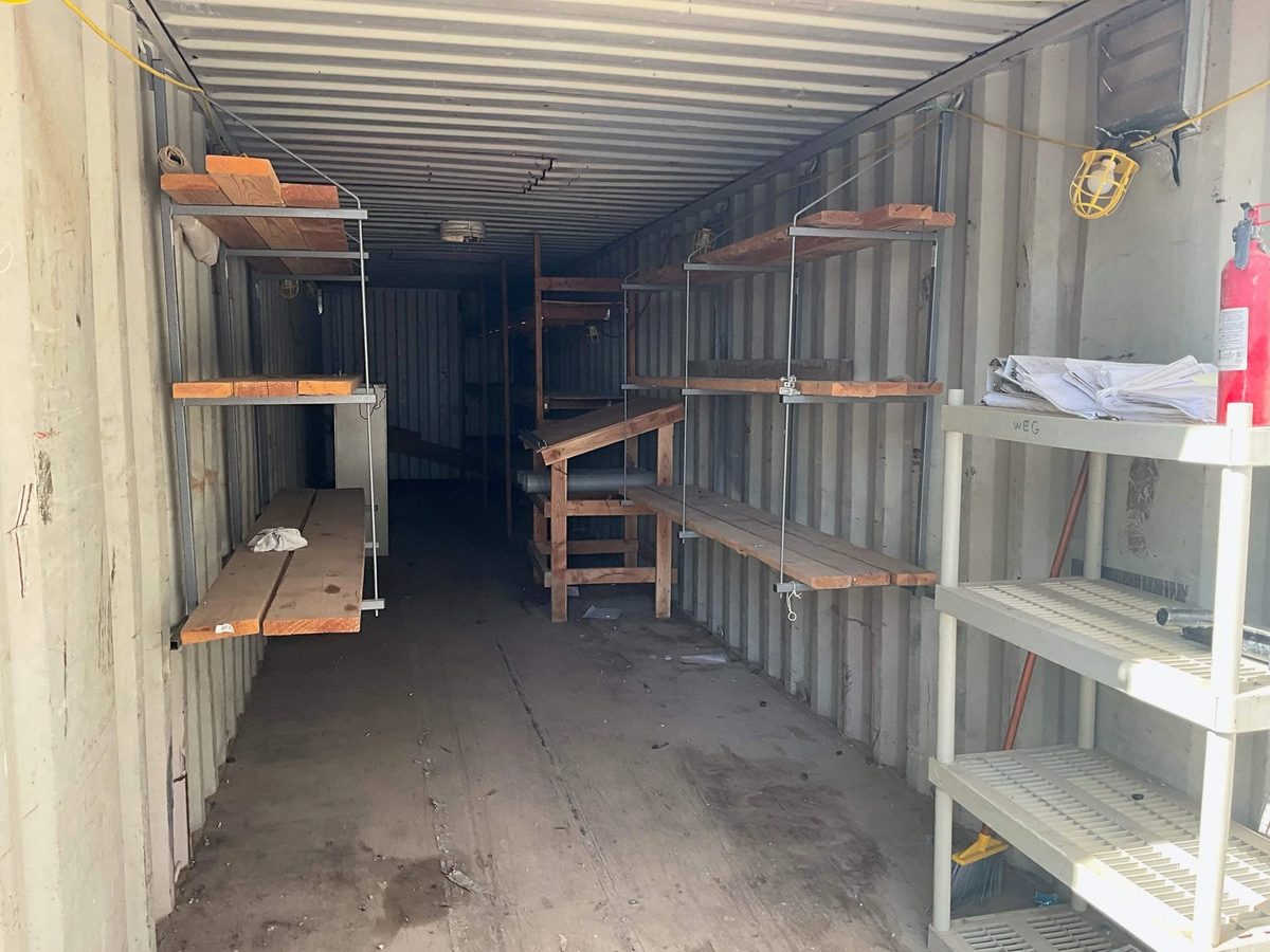 40ft Used Shipping Container – Double Doors at Both Ends – container interior with wooden shelving and scattered storage supplies