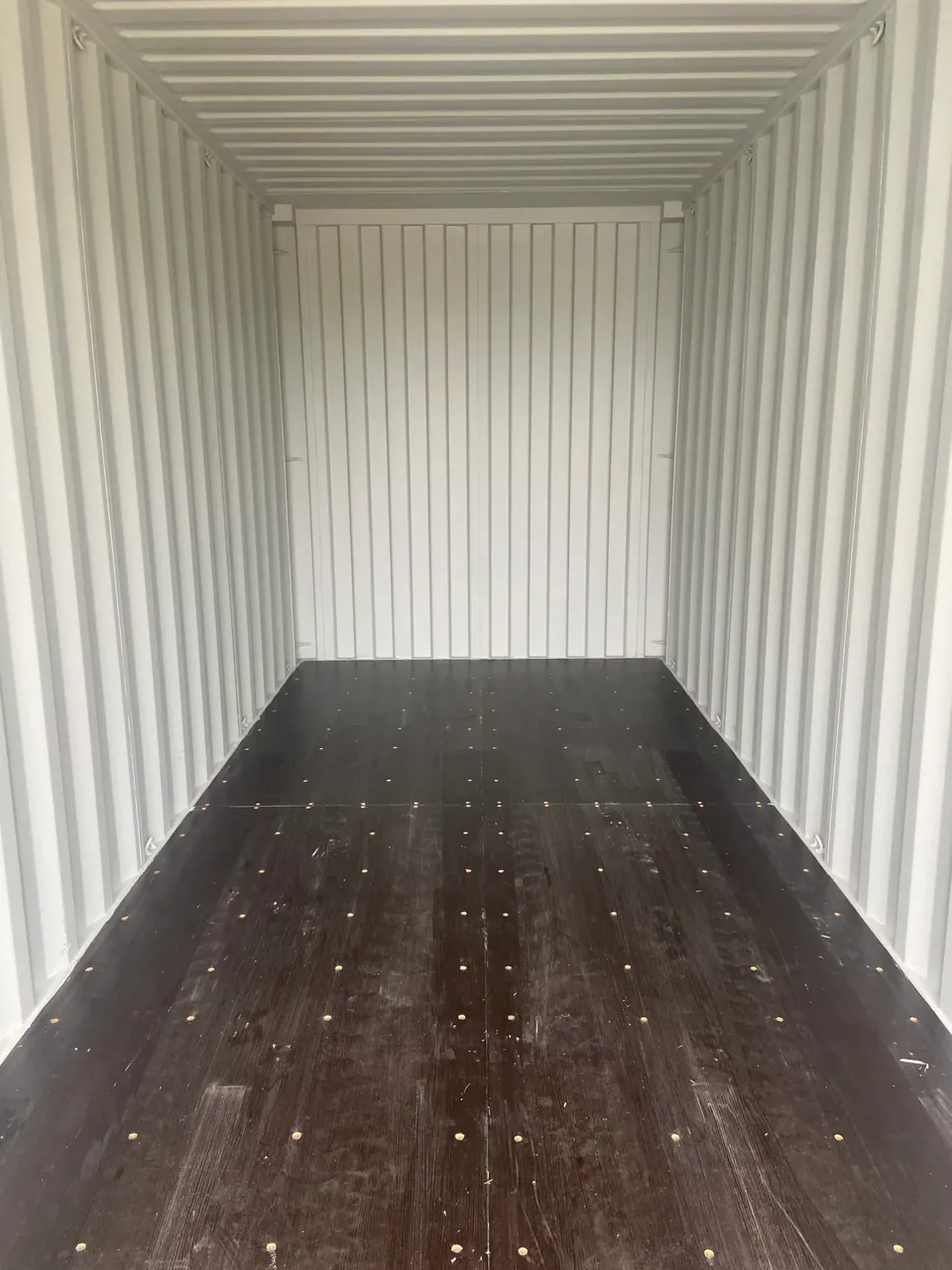 20ft High Cube Shipping Container – One-Trip, Extra Height – empty container interior with light walls and dark wooden floor