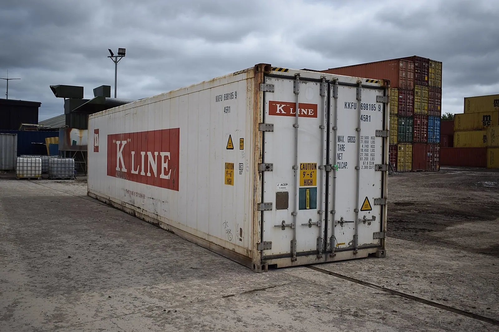 40ft Refrigerated Shipping Container – Digital Temperature Control – White refrigerated container with closed cargo doors and stacked containers in the yard