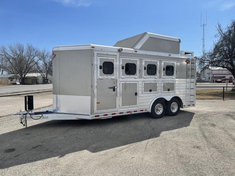 2016 Hart Ultimate 4 Horse Trailer – Champagne, Hay Pod – A three-quarter exterior view of a silver horse trailer on a paved lot
