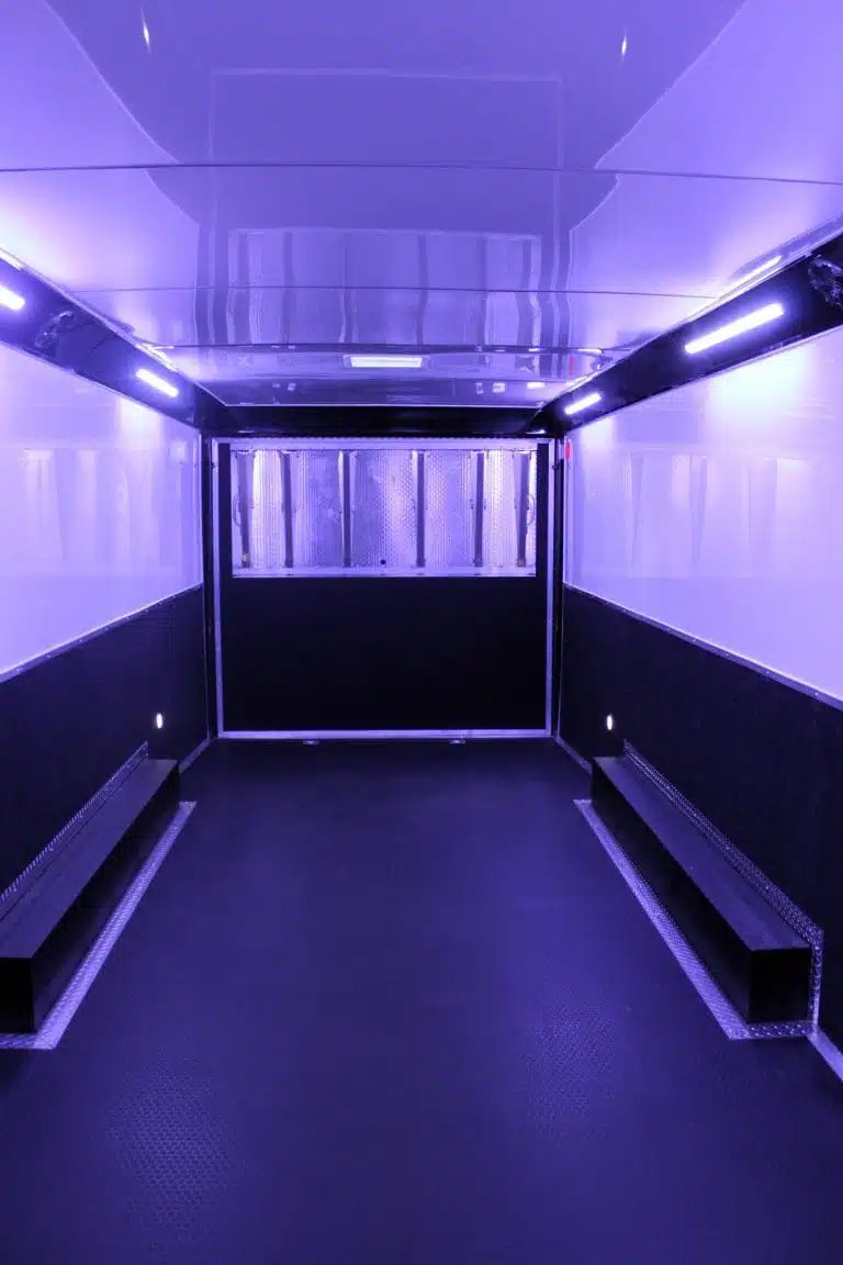 2025 Haulmark Edge 28 ft Enclosed Car Trailer – White – Interior view of the trailer showing purple accent lighting and reflective surfaces
