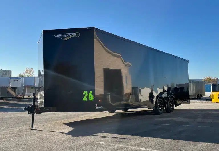 2025 Millennium 26 ft Car Hauler – Black-Out – Front three-quarter view of a black enclosed car hauler trailer against clear blue sky