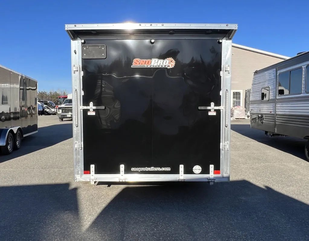 2024 Sno Pro 22 ft Snowmobile Trailer – Extra Height – Direct rear view of the closed black ramp door with manufacturer decals