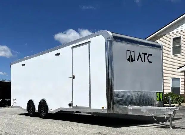 2025 ATC 24 ft Car Hauler – Large Escape Door – Right side exterior three-quarter view showing the hitch, side door, and dual axles