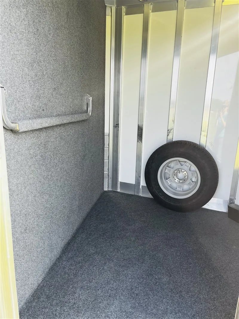 2015 4 Star 2 Horse Bumper Pull – Slant Load, Rear Tack – Corner of the tack room showing carpeted walls and a spare tire